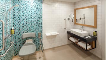 Un baño con ducha, inodoro, lavamanos y espejo.