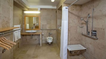 Une salle de bain équipée d’un lavabo, de toilettes, d’une douche et d’un miroir.