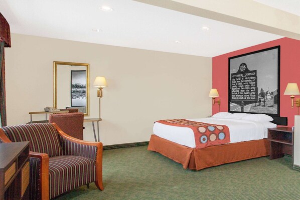 A hotel room with a bed, a chair, a desk, and a lamp. - Super 8 by Wyndham Gettysburg (Gettysburg)