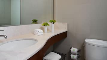 Un bagno moderno con uno specchio grande, un lavandino, un water e un porta asciugamani.