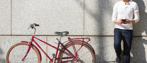 A red bicycle parked against a textured wall.