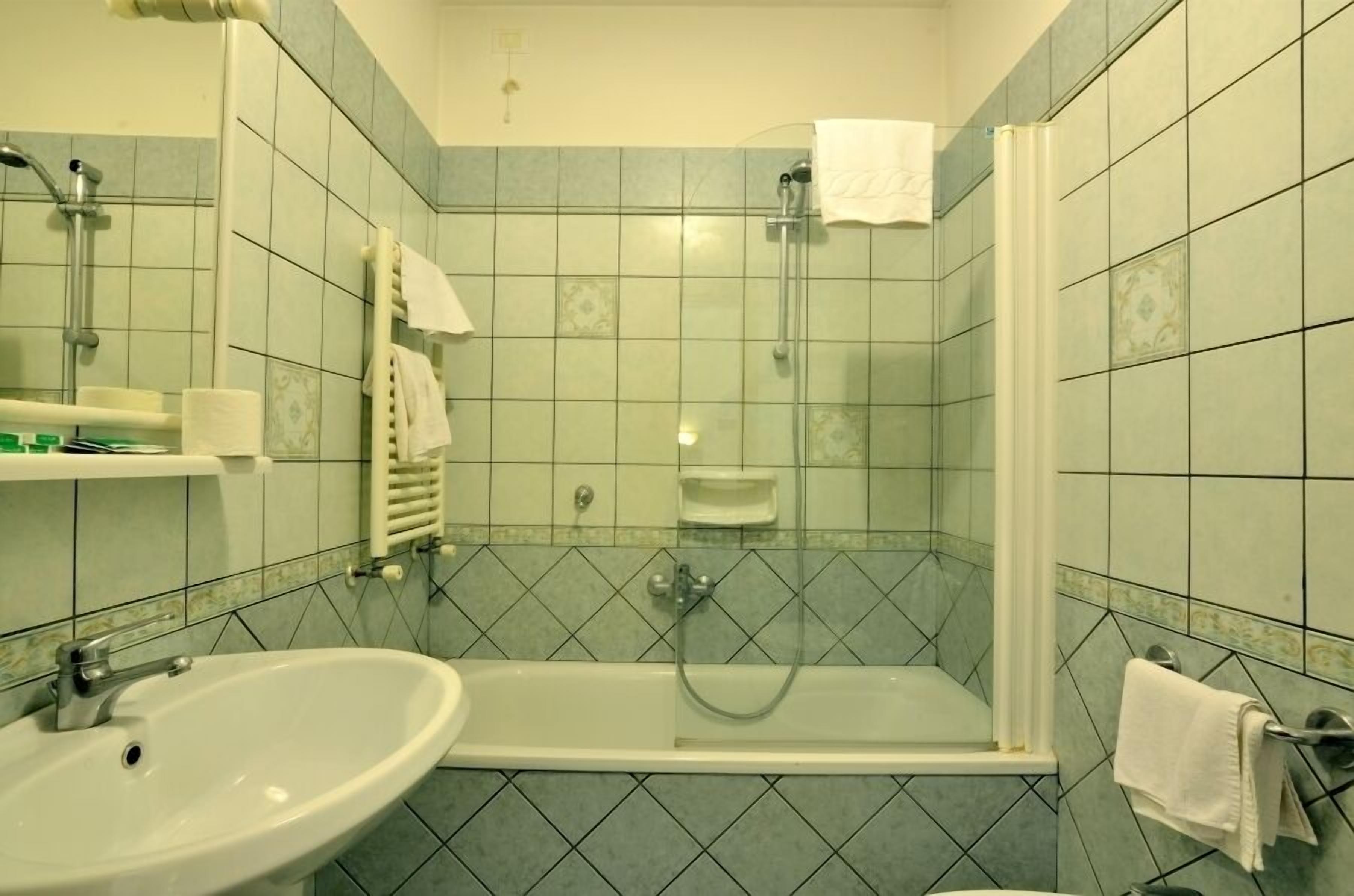 Un baño con lavamanos, ducha e inodoro.