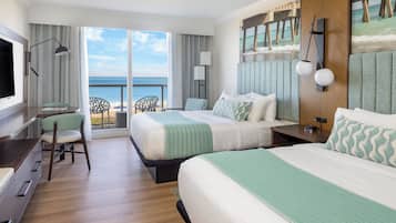 A hotel room with two beds, a desk, a chair, and a view of the ocean.