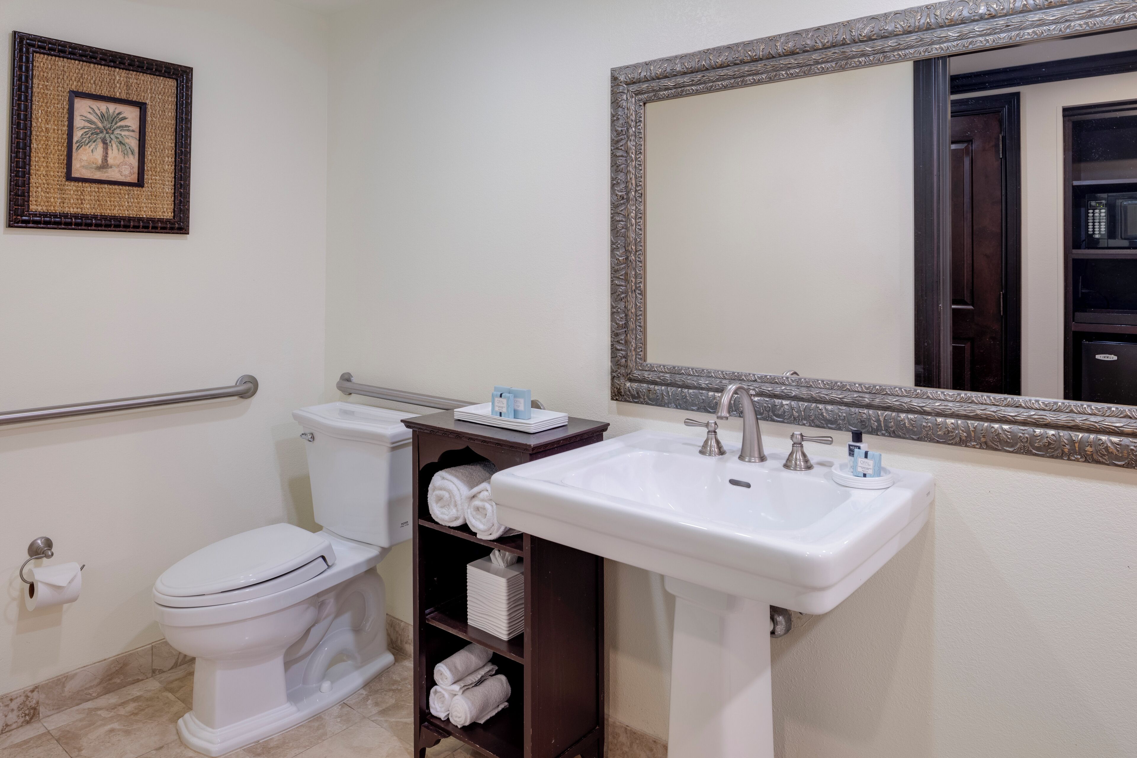 Une salle de bain avec des toilettes, un lavabo et un miroir.