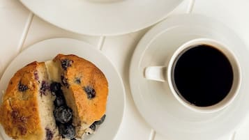 Un desayuno con pastelería, guacamole y café.