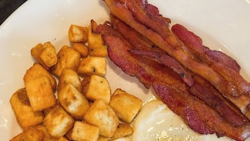 A breakfast plate with fried eggs, bacon, and hash browns.