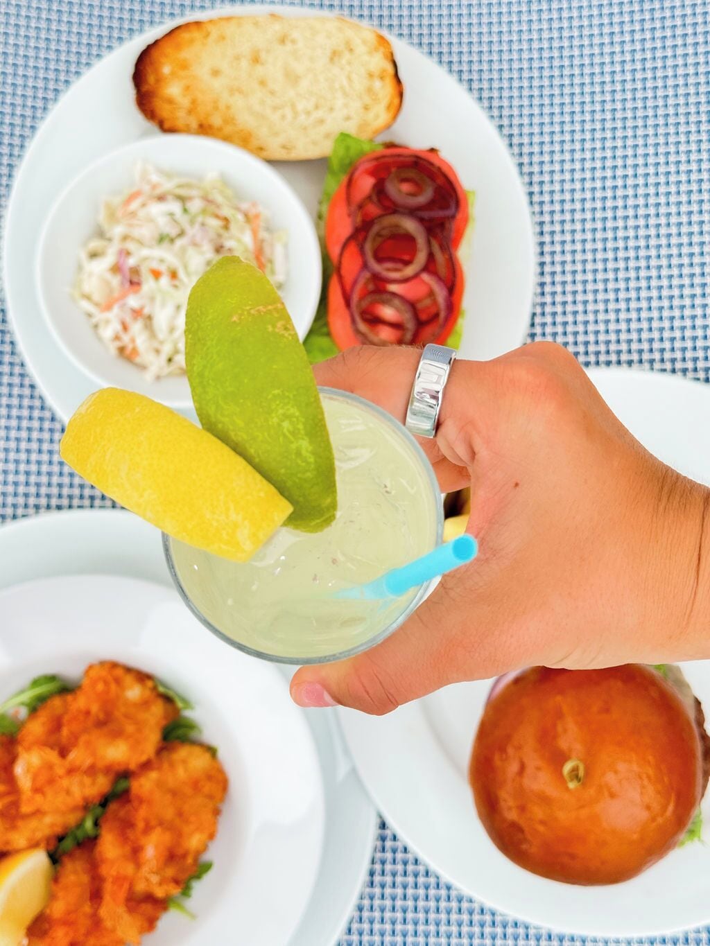 A meal with a salad, bread, and a drink with lime slices.