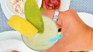 A meal with a salad, bread, and a drink with lime slices.