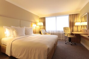 Relax in this serene space with a large bed, two bedside tables, and a desk for work or leisure.