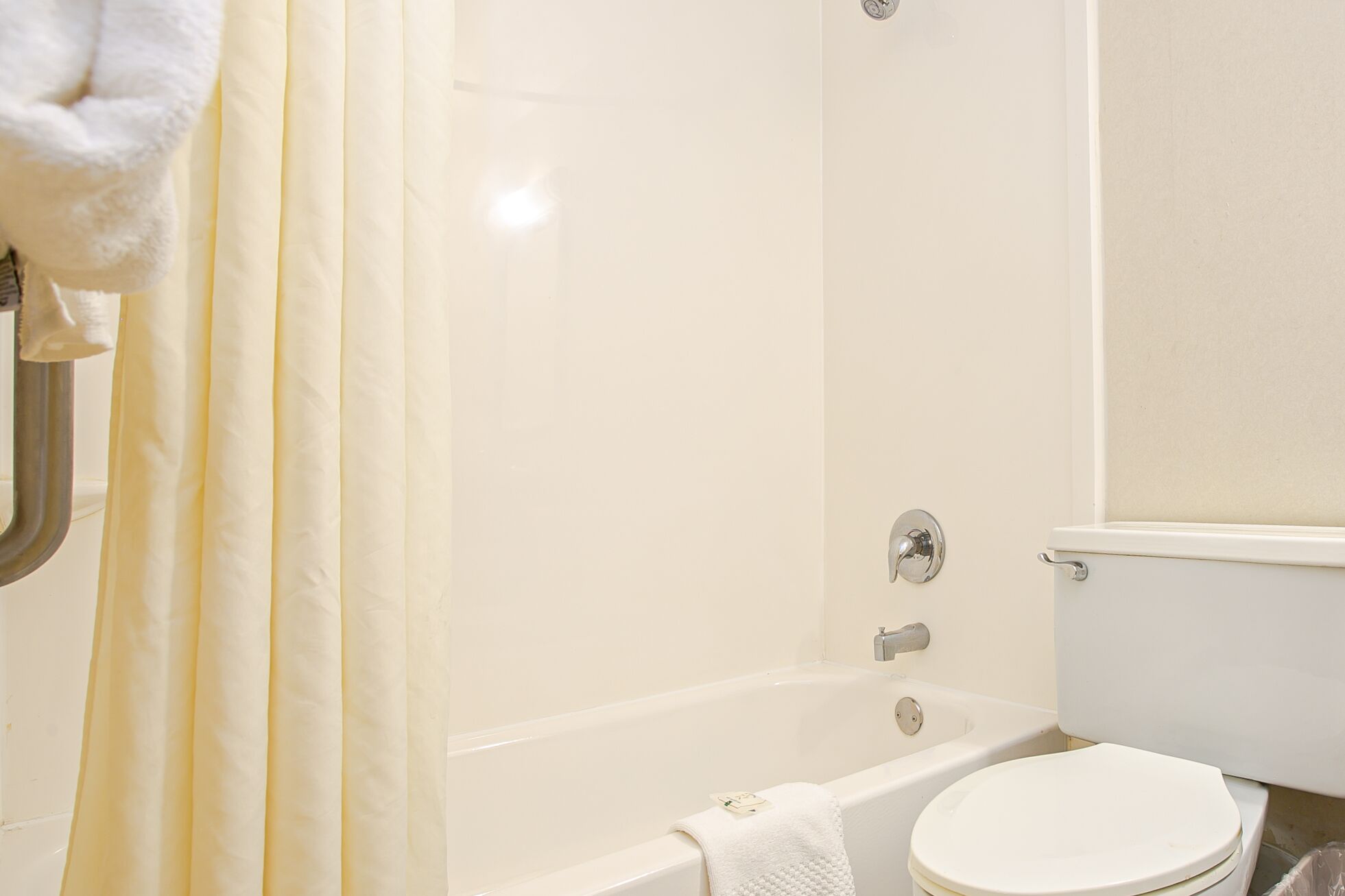Un baño con bañera, inodoro y cortina de ducha.