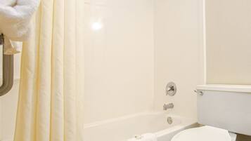 Un baño con bañera, inodoro y cortina de ducha.