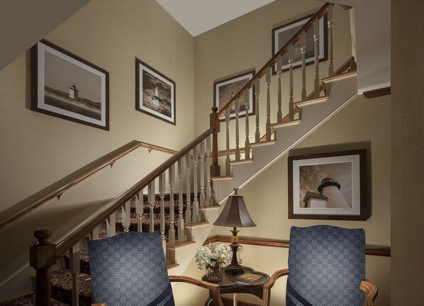 A staircase with wooden railings and a lamp on a side table. - Inn on the Square (Falmouth)