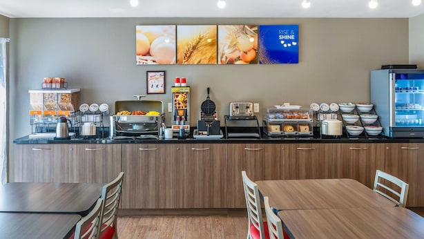 A breakfast bar with coffee machines, a fruit display, and a refrigerator.