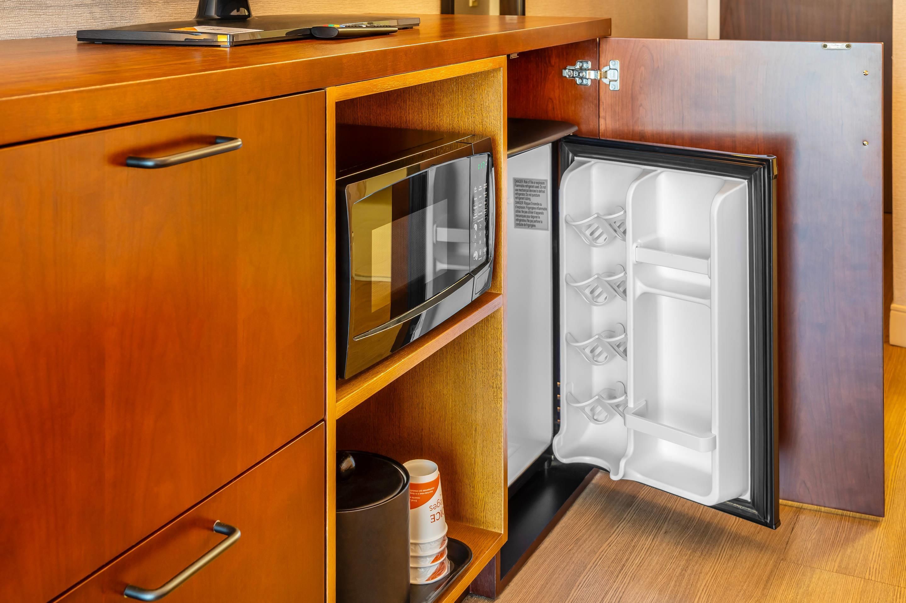 A compact kitchen with a microwave, a small refrigerator, and a coffee maker.