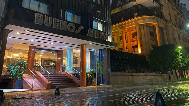 A hotel entrance with a staircase leading up to the entrance, a sign reading "BUENOS AIRES," and a classical building facade in the background. - Gran Hotel Buenos Aires (Buenos Aires)