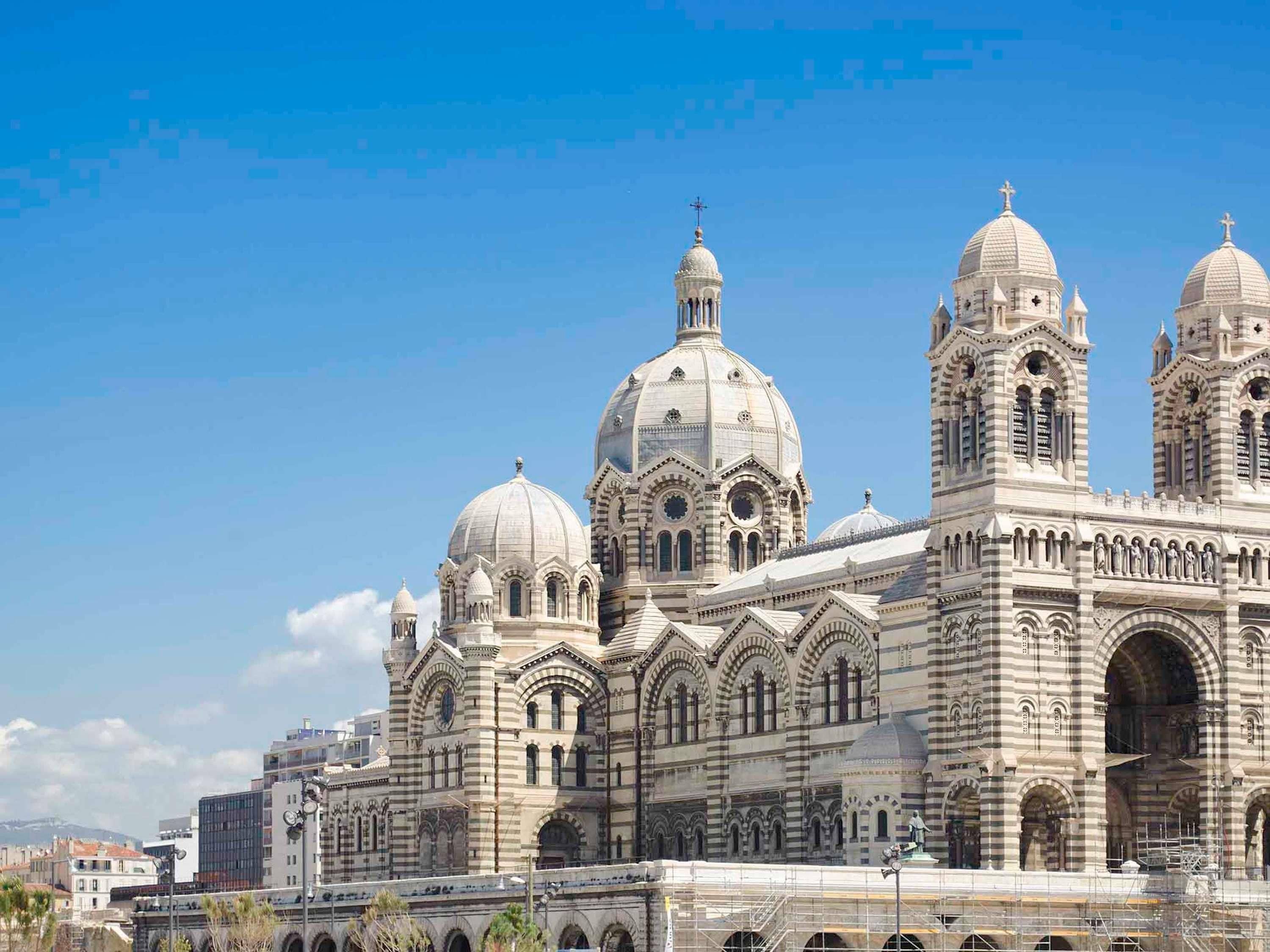 A large, historic building with multiple domes and arched windows.