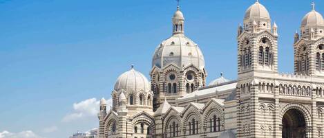 A large, historic building with multiple domes and arched windows.