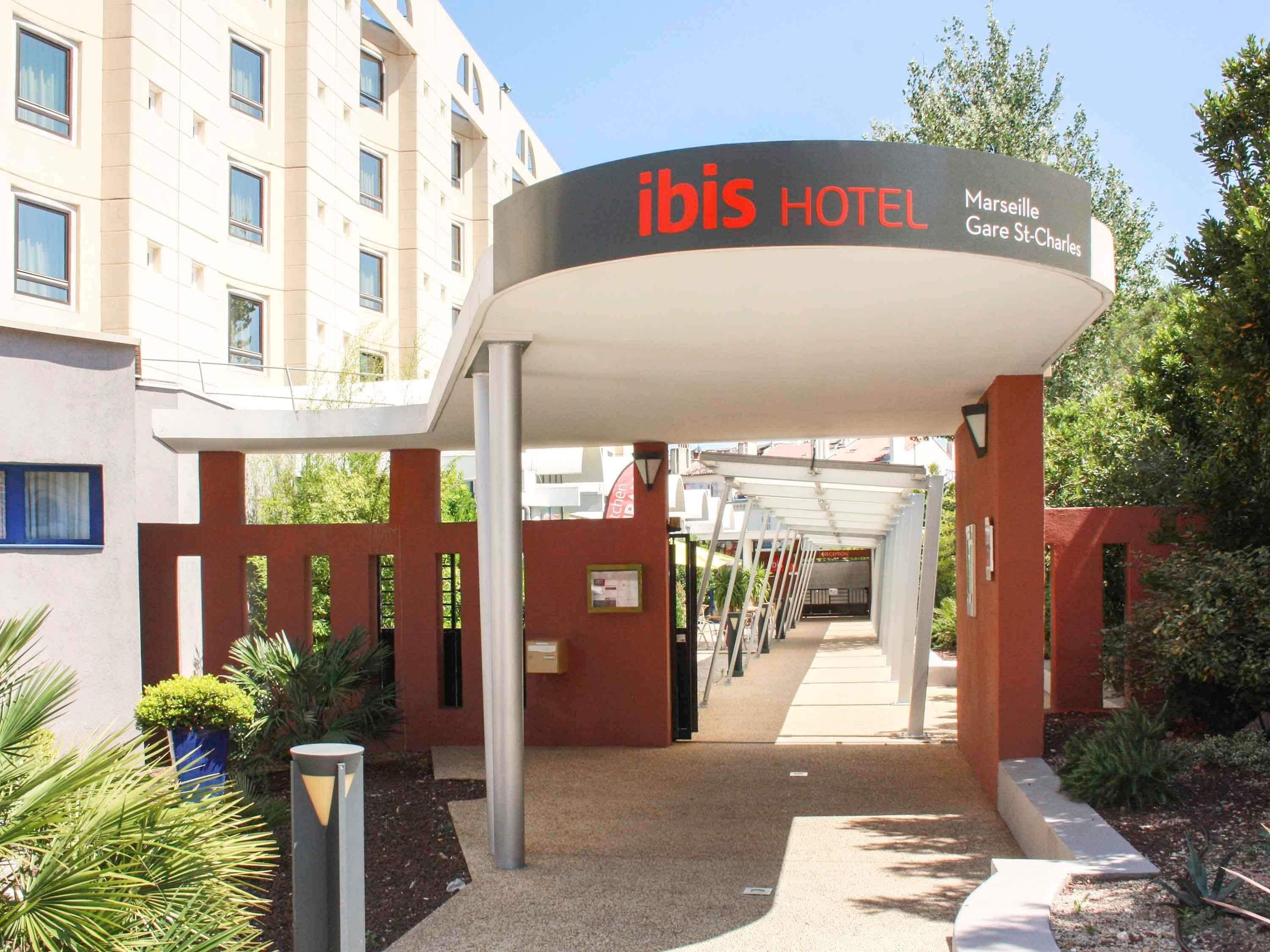 La entrada del hotel ibis Marseille Gare St-Charles, con un vestíbulo cubierto y vista del edificio al fondo.