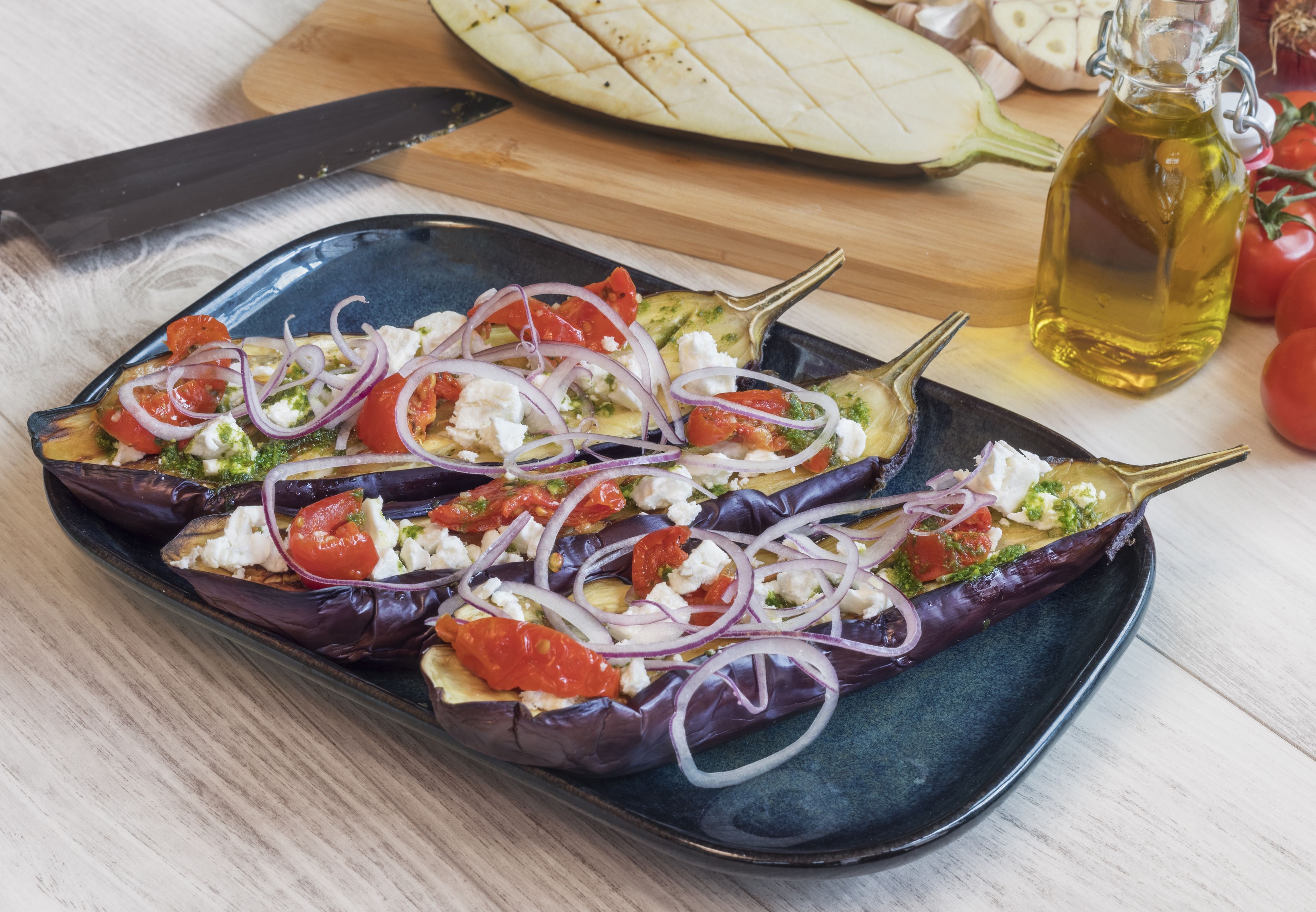 Un plato de berenjenas rellenas con tomates, cebollas y queso feta.