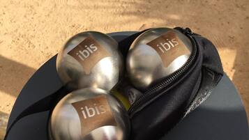 Un bolso negro con tres bolas metálicas con la etiqueta 'ibis' y una gorra negra con cremallera.