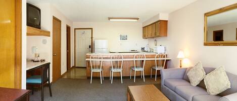 A compact living space with a kitchenette, a dining area, and a seating area.