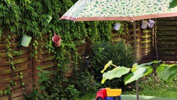 A garden area with a wooden fence, a green bench, and a toy dump truck.