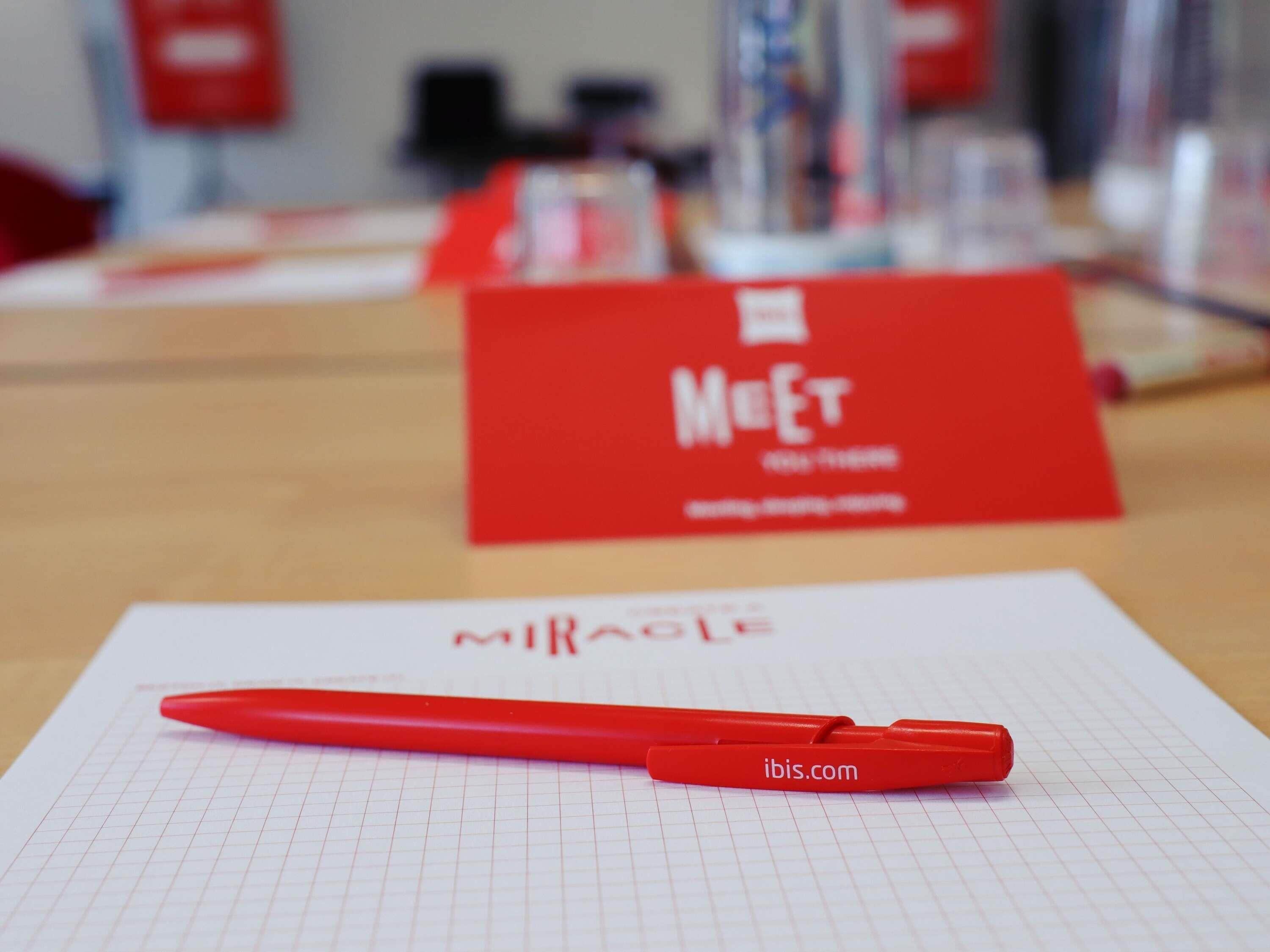 Un stylo rouge posé sur une feuille de papier millimétré, avec un arrière-plan flou.
