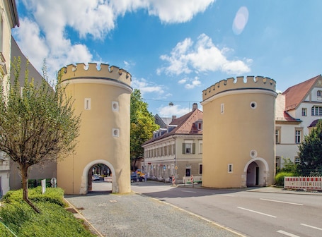 A historic building with two round towers and arched entrances.