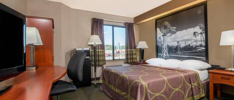 A hotel room with a bed, desk, chair, TV, and a large window with curtains.