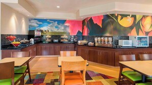 Une cuisine moderne avec une fresque murale, un four à micro-ondes et une machine à café.