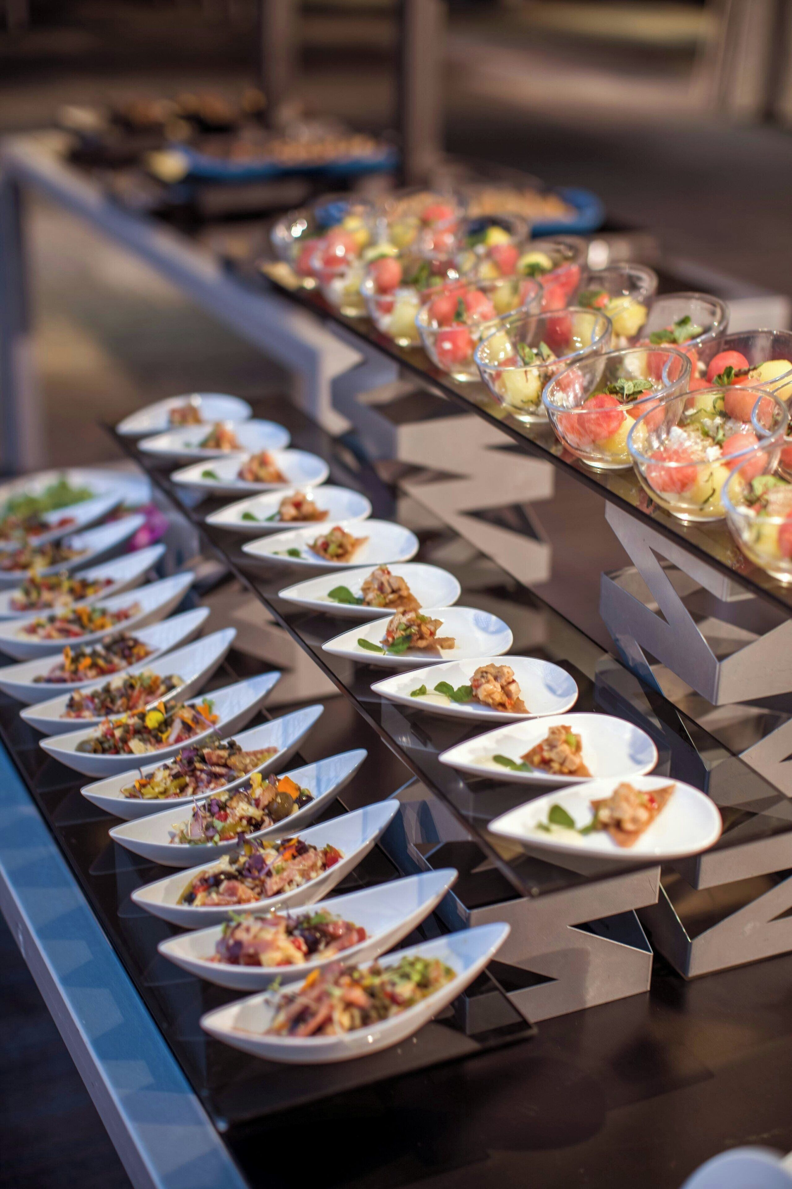 A buffet with various dishes arranged on plates and bowls.