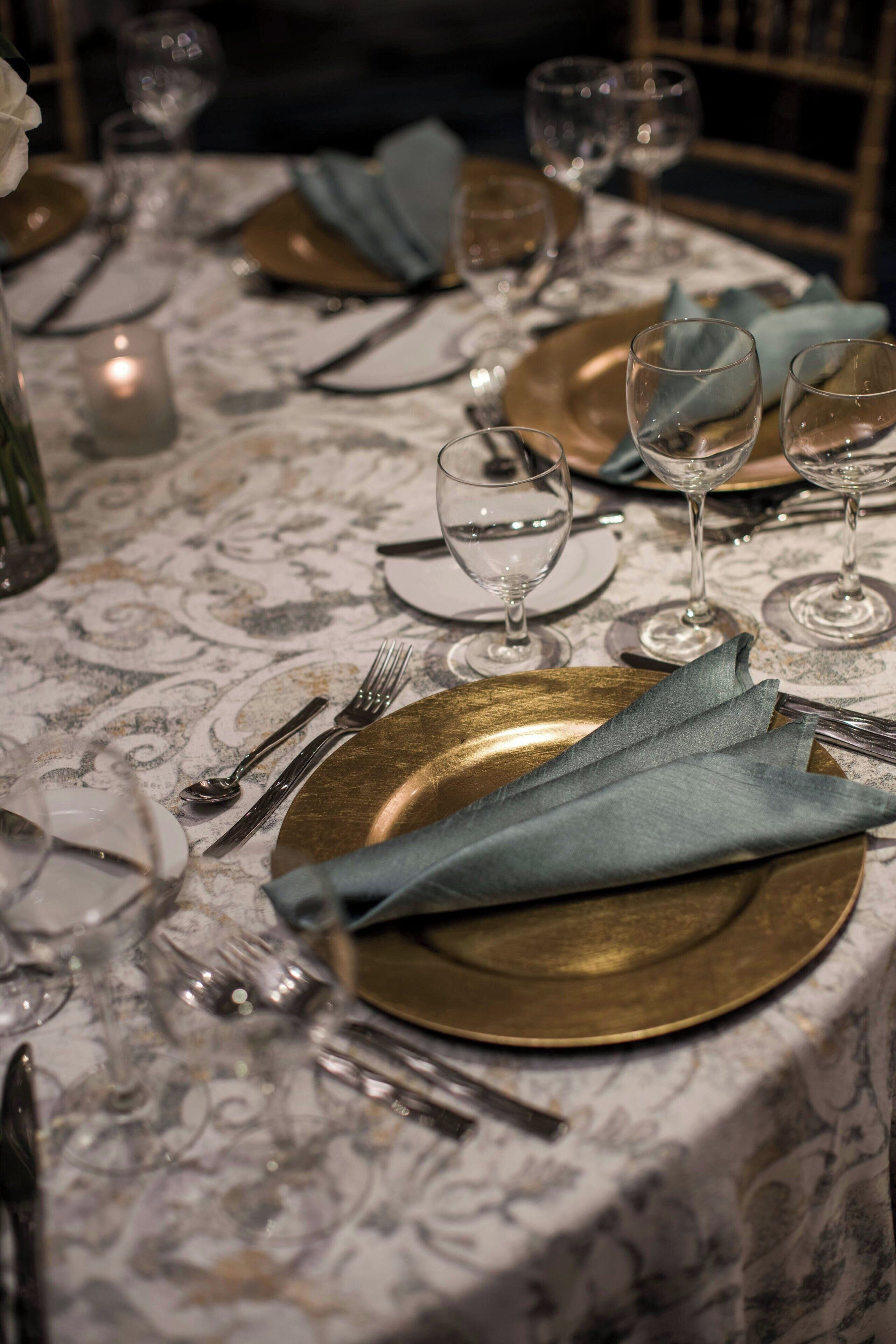 A table set for a meal with plates, cutlery, and glasses.