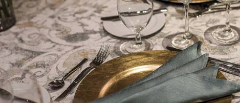 A table set for a meal with plates, cutlery, and glasses.