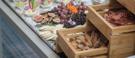 A buffet with various food items including fruits, vegetables, and meats.