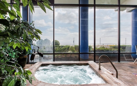 A hot tub with a view of the ocean through large windows.