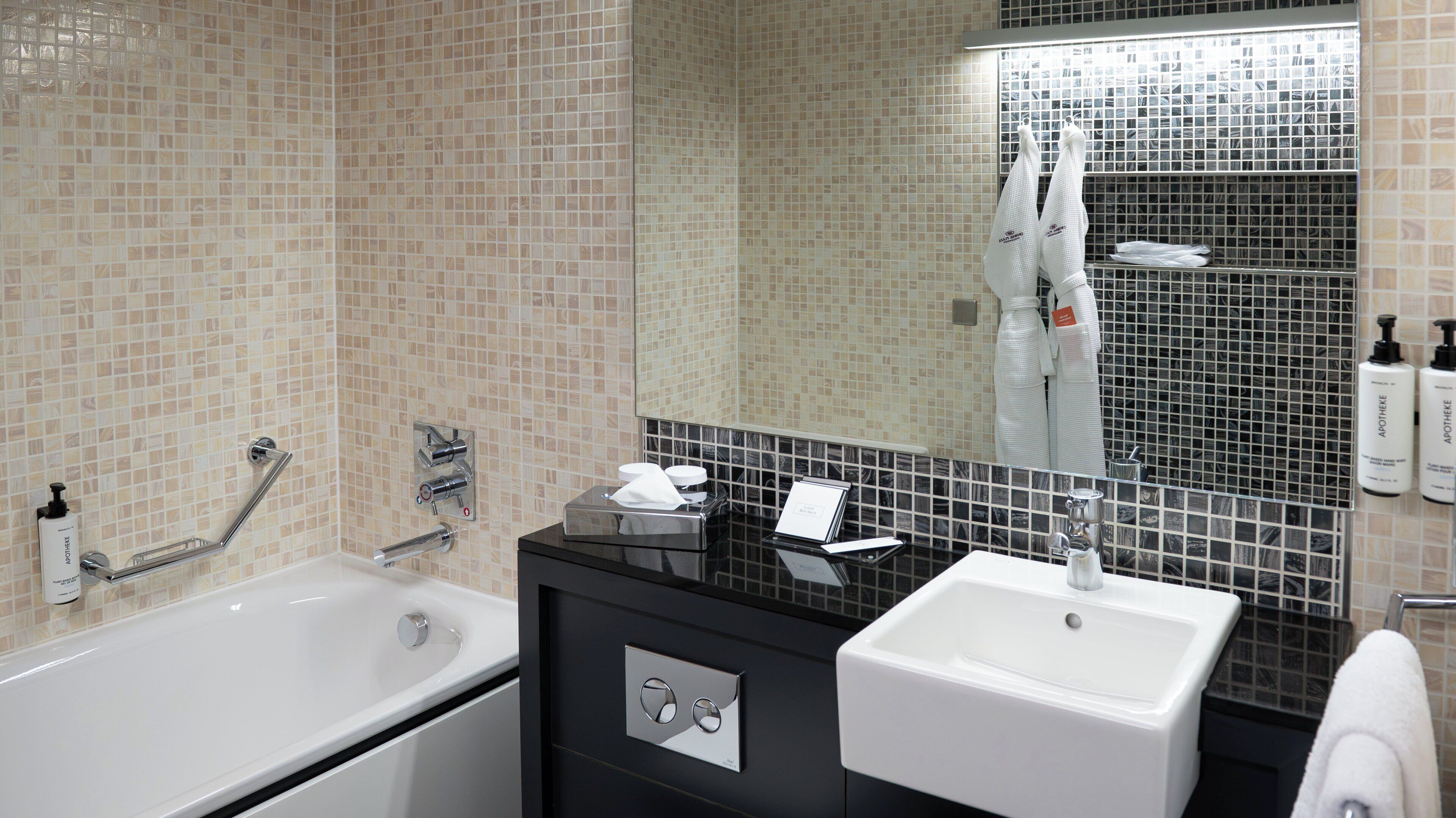 Une salle de bain moderne avec une baignoire, un lavabo et un miroir.