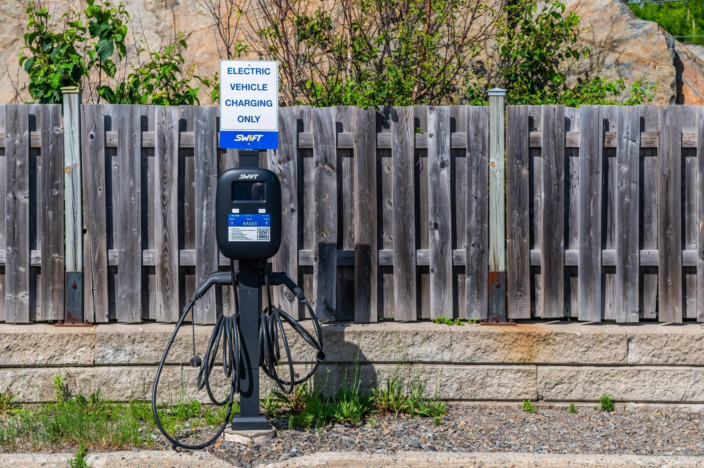 Eine Ladestation für Elektrofahrzeuge mit einem Schild, das angibt, dass sie nur für Elektrofahrzeuge bestimmt ist, mit dem Branding SWIFT.