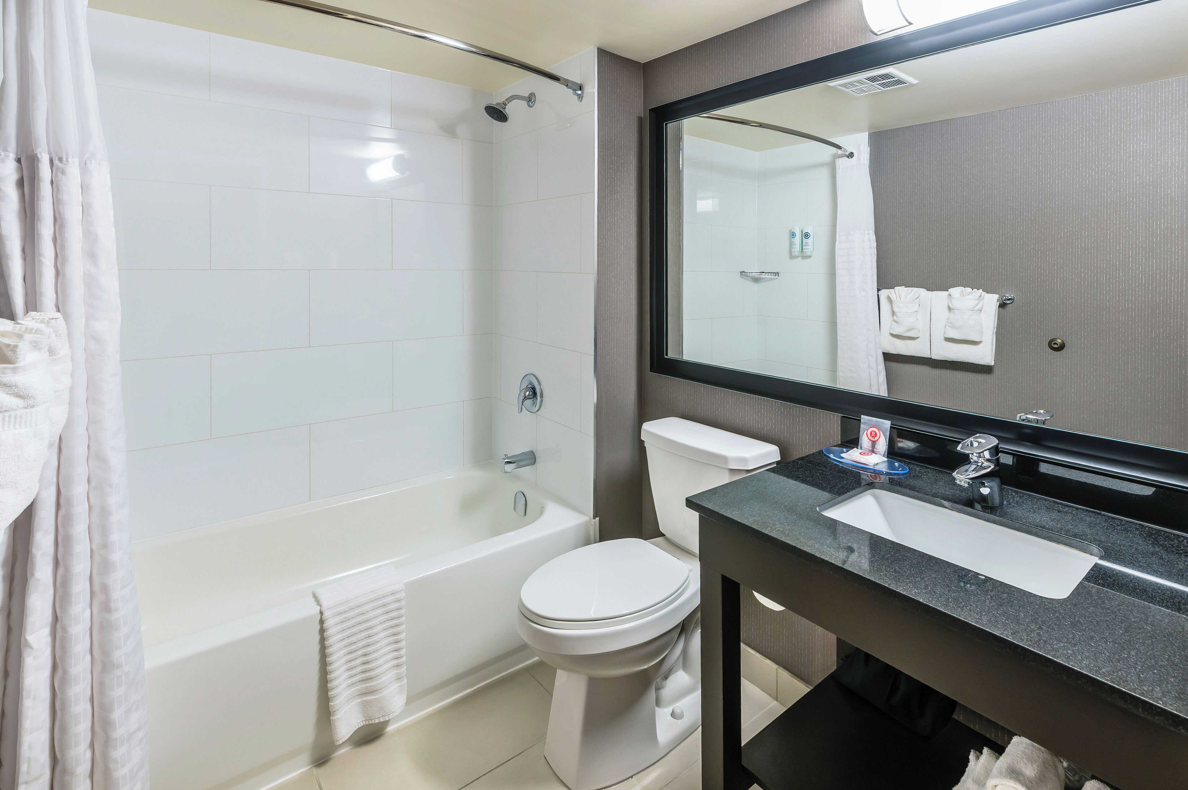 A modern bathroom with a bathtub, toilet, and sink.