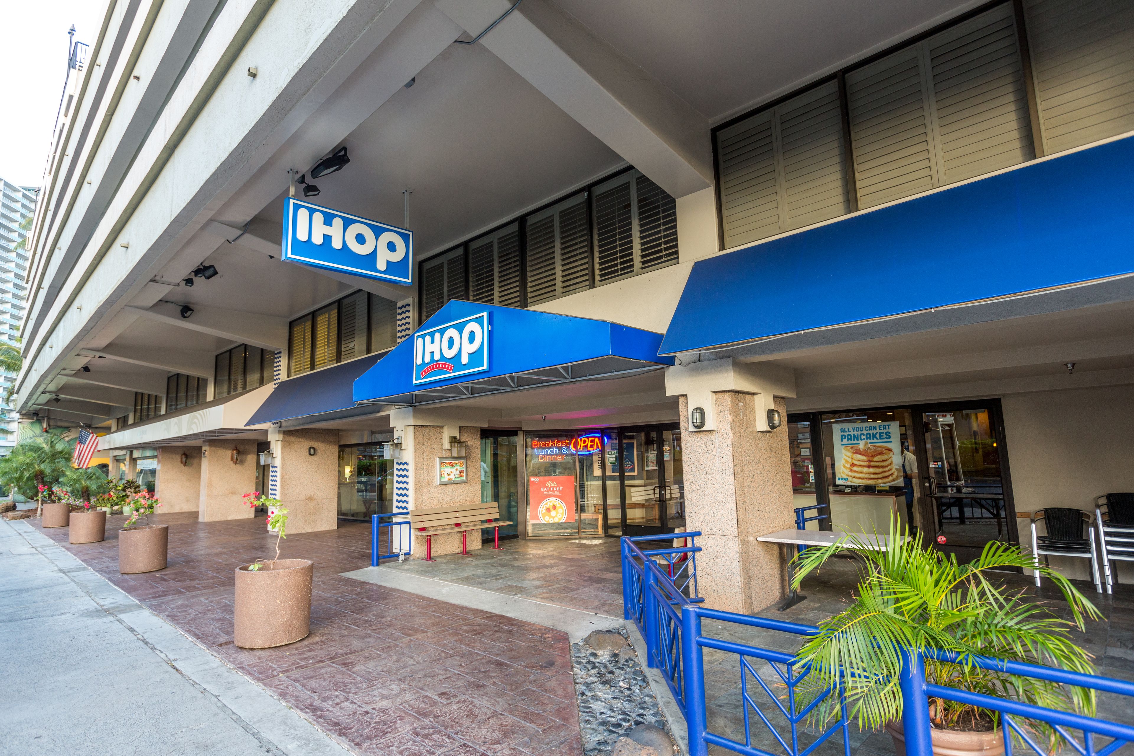 Un restaurante IHOP con terraza y toldo azul.