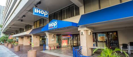 Un restaurante IHOP con terraza y toldo azul.