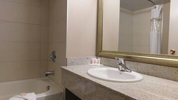 Une salle de bain avec une baignoire, un lavabo et un miroir.