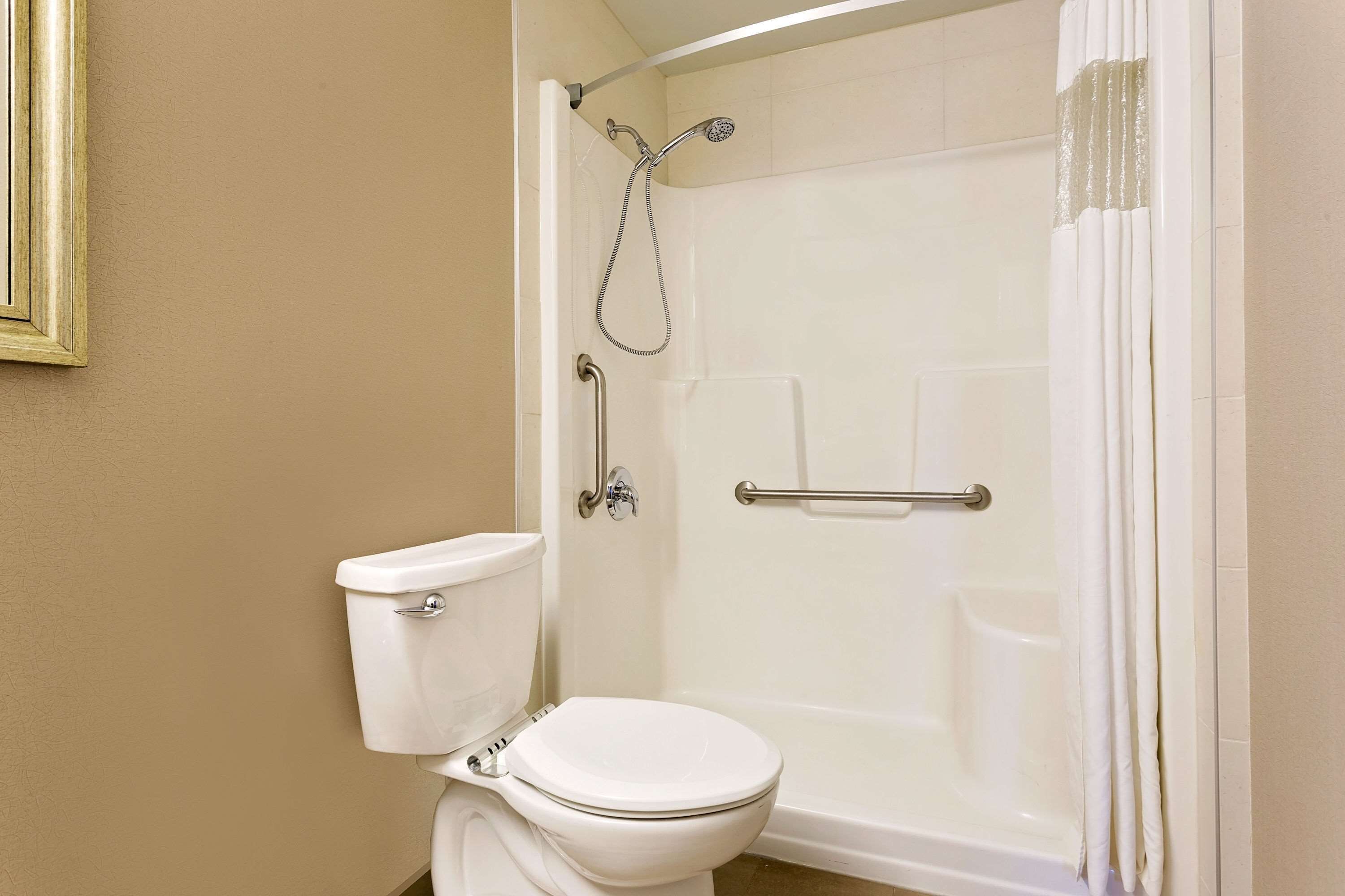 A bathroom with a toilet, a shower with a glass door, and a bathtub.