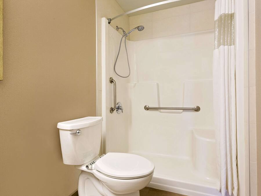 A bathroom with a toilet, a shower with a glass door, and a bathtub.