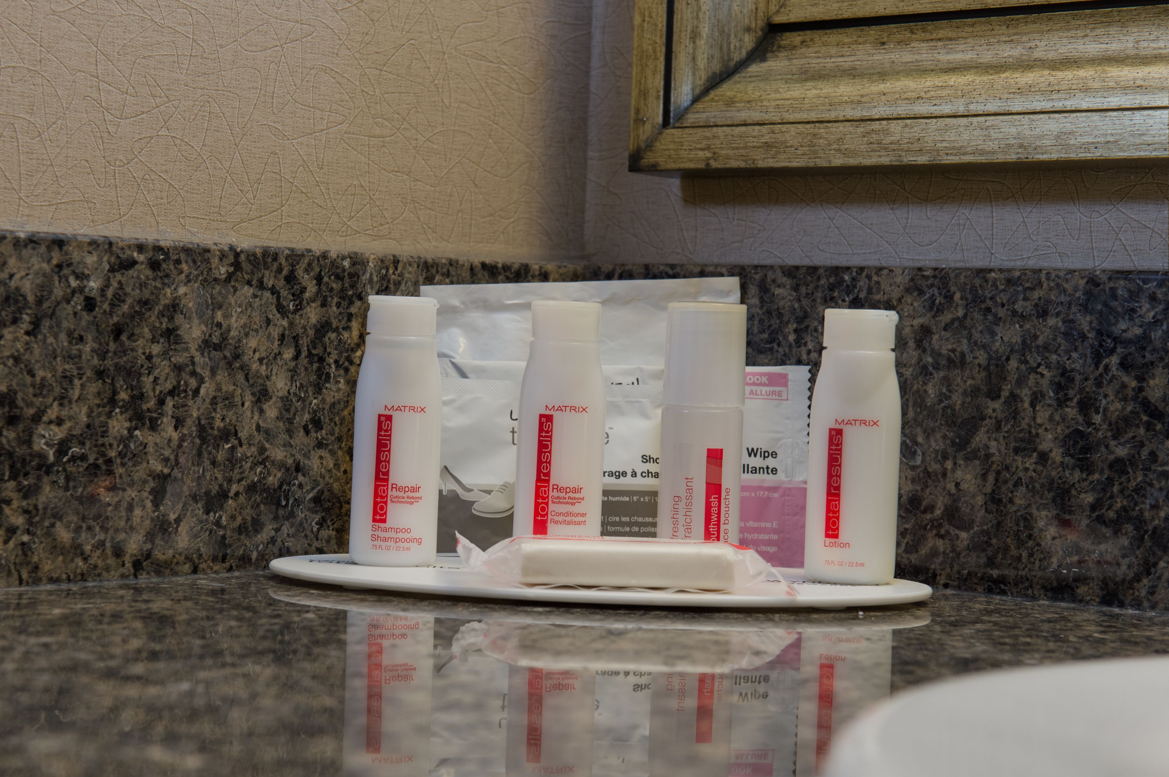 Un comptoir sur lequel se trouve un plateau contenant plusieurs bouteilles de shampoing et de lotion de la gamme Matrix Total Results.