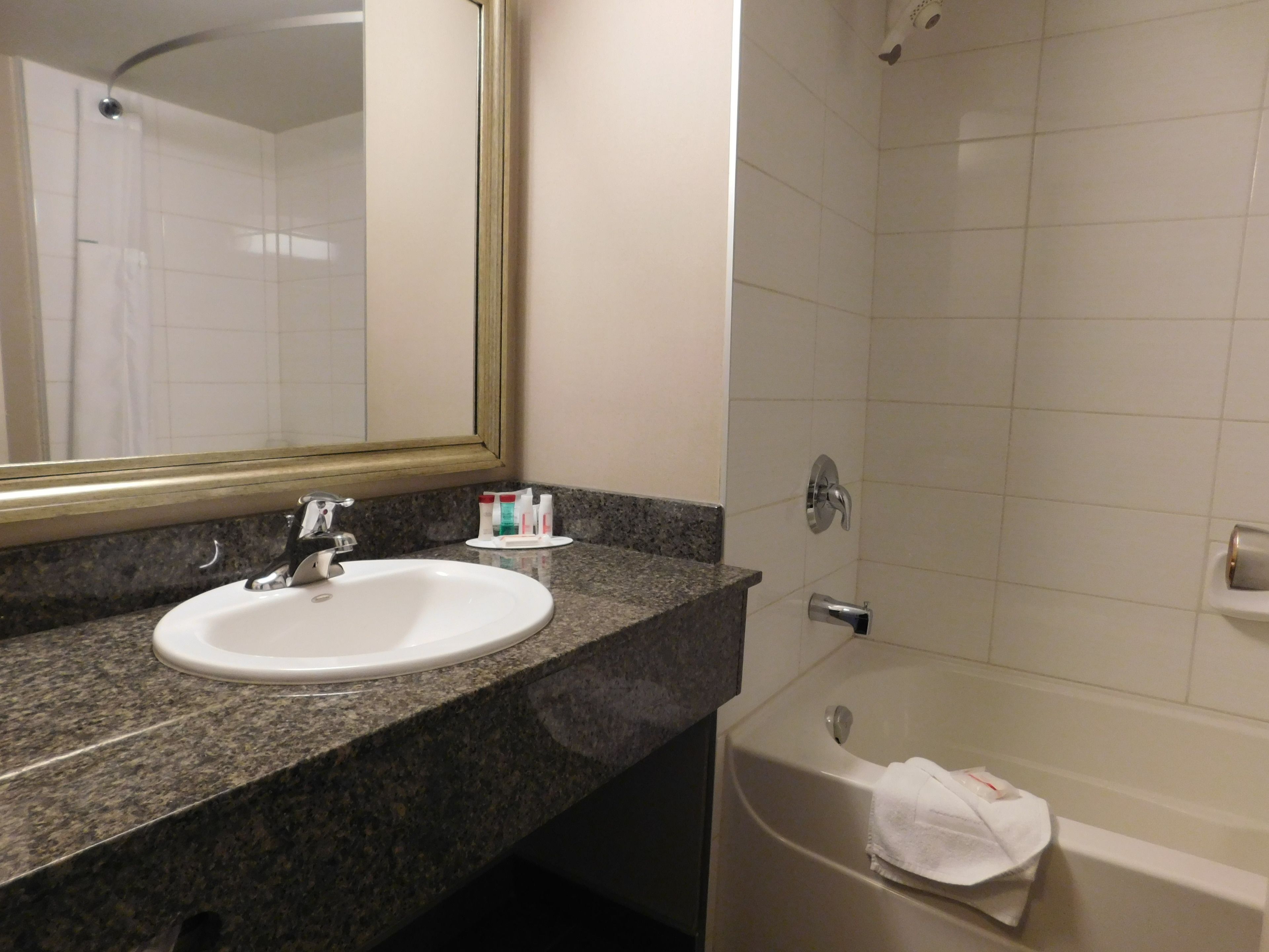 Une salle de bain avec un lavabo, un miroir et une baignoire.