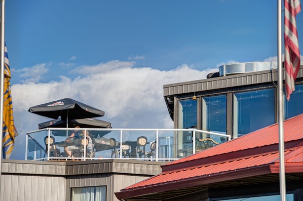 A building with a balcony, large windows, and a red roof. - Ramada by Wyndham Kamloops (Kamloops)