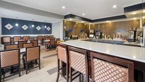 A modern restaurant with a central bar area, multiple seating options, and a variety of food and beverage displays.