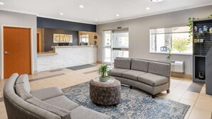 A modern lobby with a reception desk, seating area, and large windows. - Best Western Kokomo Hotel (Kokomo)