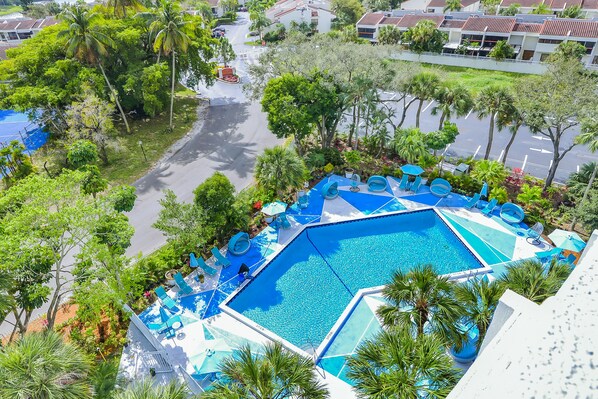 Una piscina al aire libre, sombrillas, tumbonas