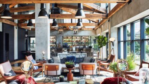 A spacious lounge area with leather chairs, a coffee table, and a bar in the background. - Hotel Kabuki, part of JdV by Hyatt (San Francisco)